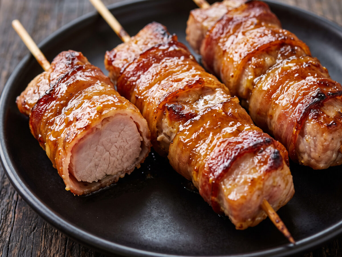 Speckumwickelte Schweinespieße mit Orangen-Senf-Glasur